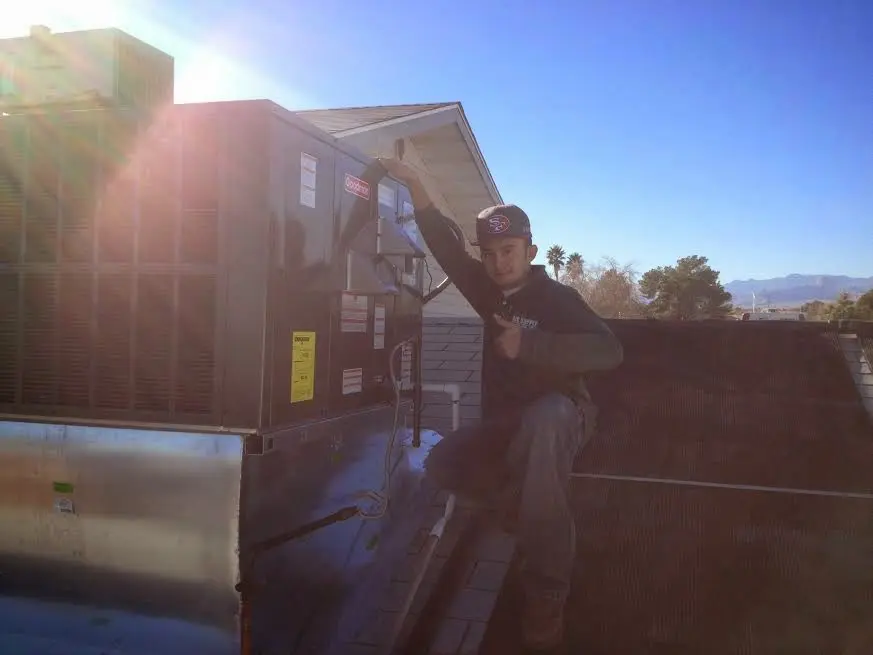 HVAC technician performing Air Duct Cleaning on a rooftop unit in Preston